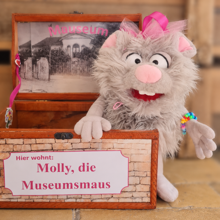 Stofftiermaus sitzt in Holzkiste